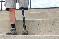 Image of a man with prosthetic leg standing on concrete steps outside