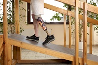 Image of a person walking up a wooden ramp using a prosthetic leg